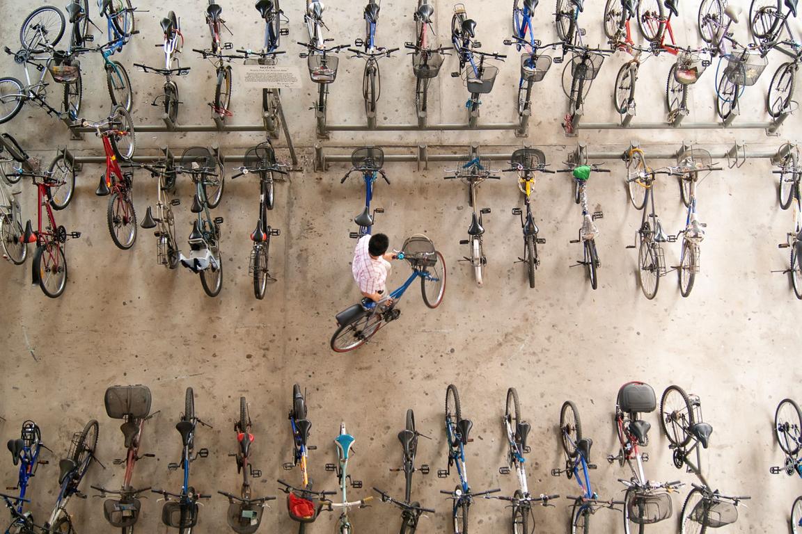 man putting bicycle up aerial view man putting bicycle up aerial view